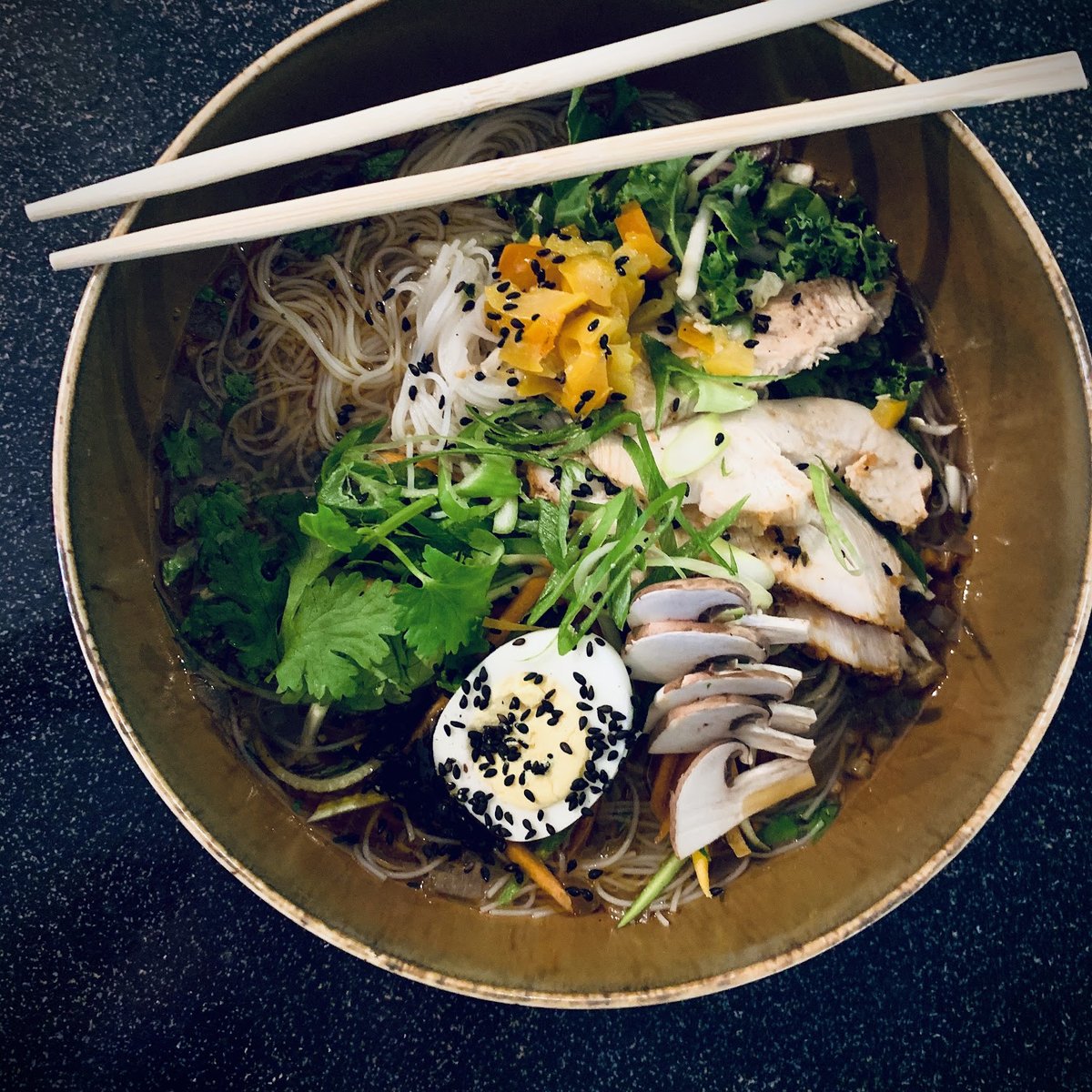 Un bol poke garni de saumon, de légumes et de nouilles