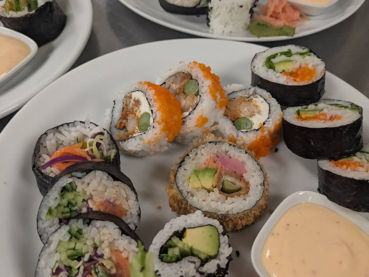 Plusieurs plateaux de sushis assortis, avec leur sauce