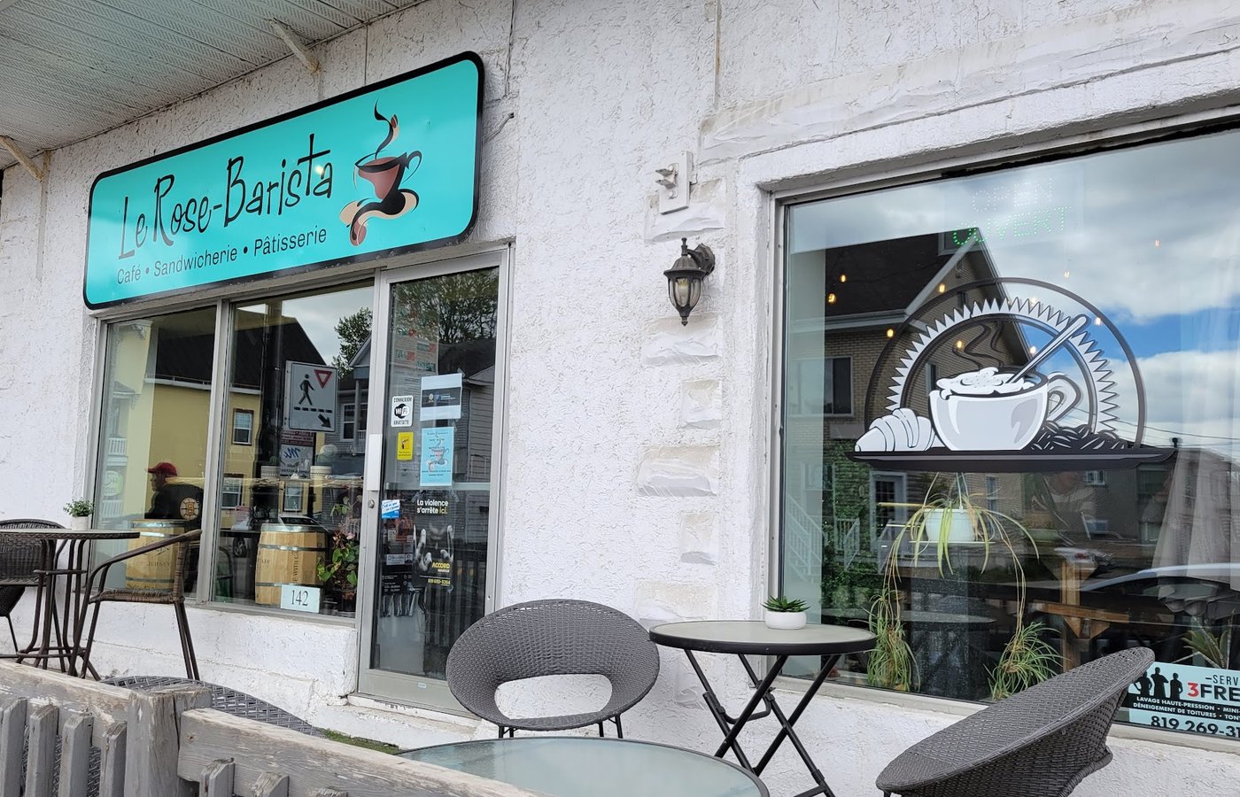 La devanture turquoise du café et ses tables sur le trottoir